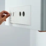 femme qui règle sa chaudière à gaz dans son appartement