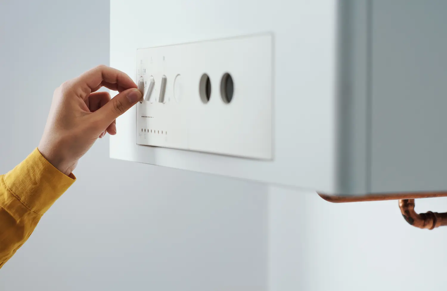 femme qui règle sa chaudière à gaz dans son appartement