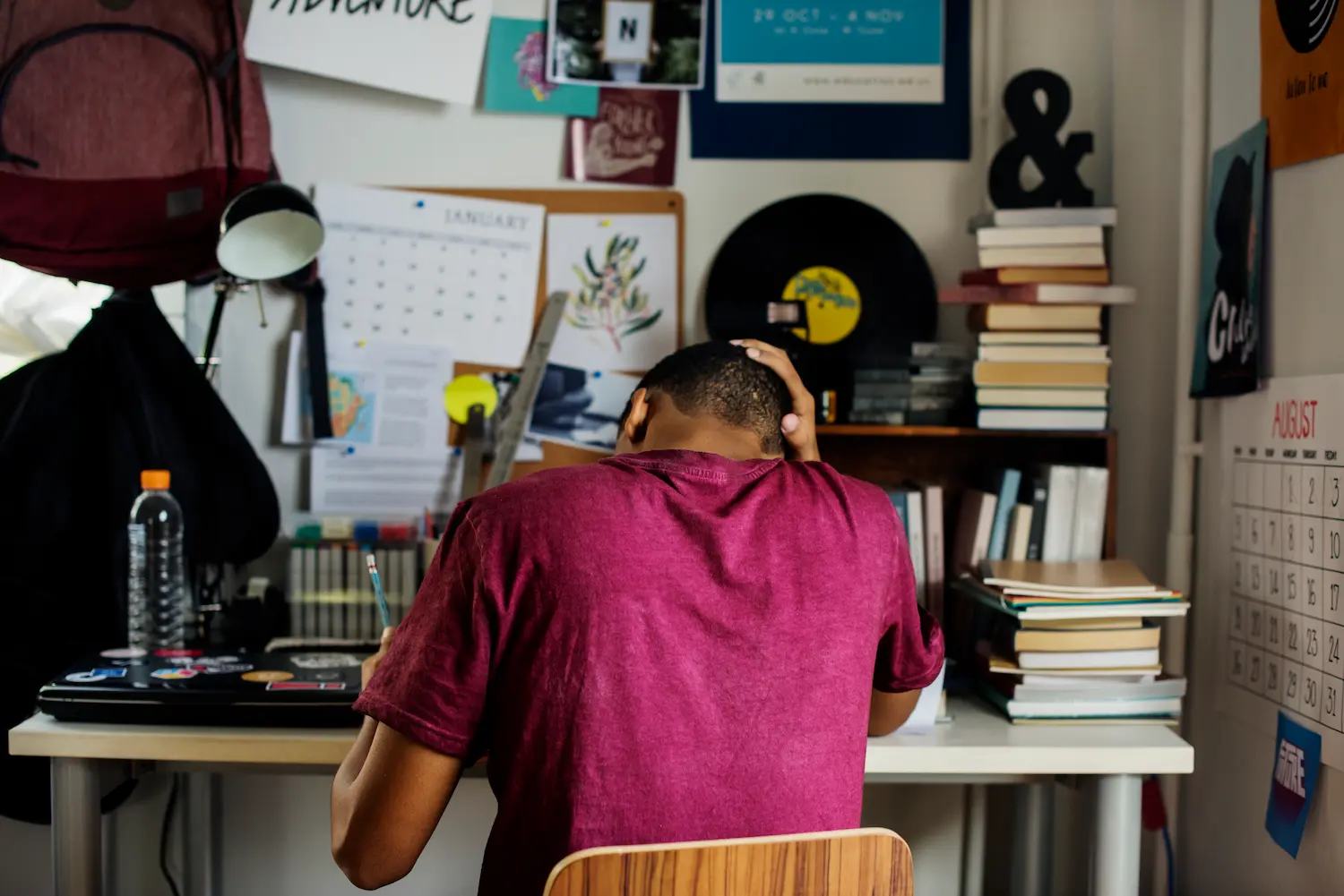 étudiant de dos stressé sur son bureau dans son studio à cause de sa facture d'électricité
