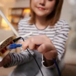 une femme dans son appartement connectant un câble Ethernet à sa box WiFi afin d'avoir une meilleure connexion